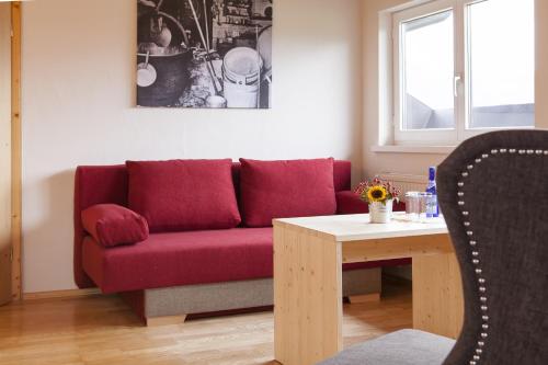 a living room with a red couch and a table at Alpe Oberstdorf in Oberstdorf
