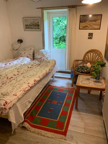 a bedroom with a bed and a table and a window at Ingridsboplads in Vildbjerg