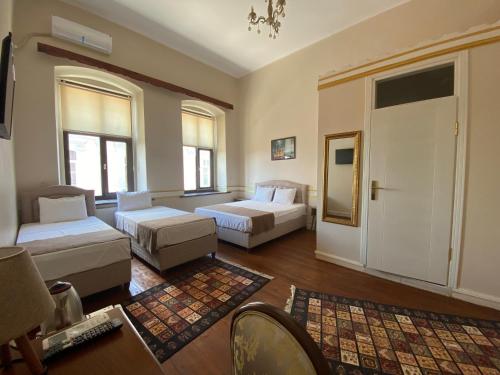 een grote kamer met 2 bedden en een bank bij Oasis Hotel Edirne in Edirne