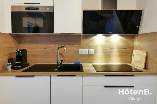 une cuisine avec un évier et un micro-ondes dans l'établissement Town Hall Studio - Hyper-center Limoges, à Limoges