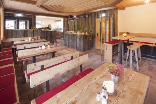 un restaurante con mesas de madera y bancos en una habitación en Alpe Oberstdorf, en Oberstdorf