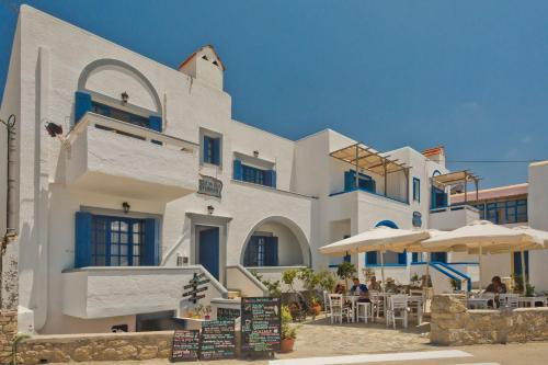 a large white building with tables and umbrellas at Aegean Sea in Lefkos Karpathou