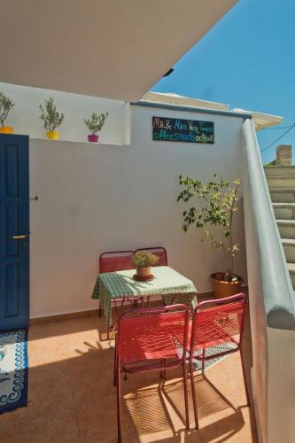 a table and two chairs on a balcony with a table and two plants at Aegean Sea in Lefkos Karpathou