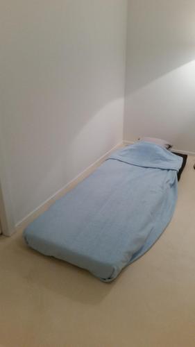 duże niebieskie łóżko w narożniku pokoju w obiekcie Gästezimmer w Zurychu