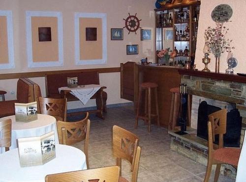 a restaurant with tables and chairs and a fireplace at Villa Sunray in Agios Ioannis Pelio