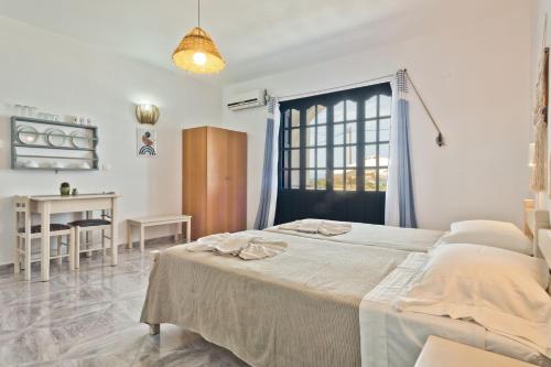 a bedroom with a bed and a desk and a window at Aegean Sea in Lefkos Karpathou