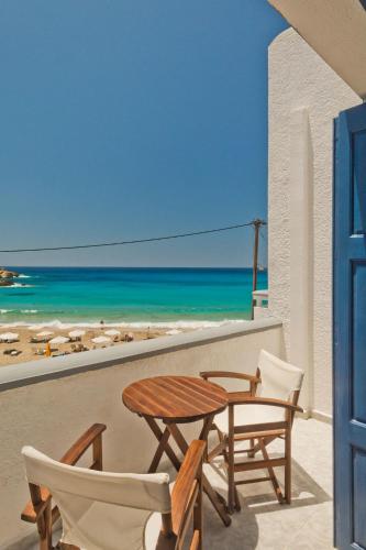 a table and chairs on a balcony with the beach at Aegean Sea in Lefkos Karpathou