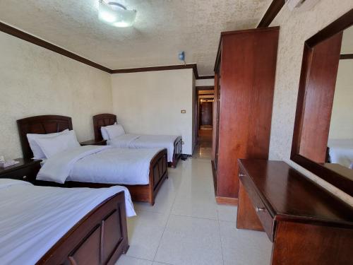 a hotel room with two beds and a desk at Nahas Plaza in Irbid