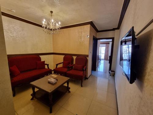 a waiting room with chairs and a table and a tv at Nahas Plaza in Irbid