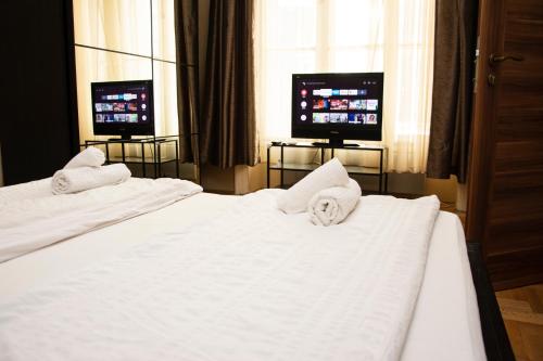 een hotelkamer met 2 bedden en 2 televisies bij Andrassy Room in Boedapest