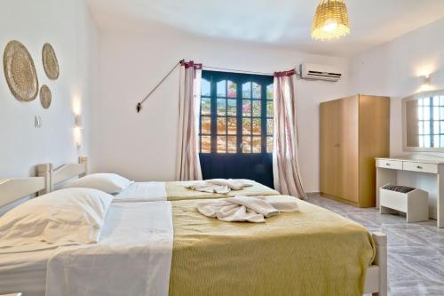 a bedroom with a large bed and a window at Aegean Sea in Lefkos Karpathou