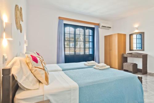 a bedroom with a blue bed with towels on it at Aegean Sea in Lefkos Karpathou