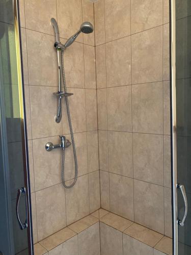 a shower with a shower head in a bathroom at RanchoBachleda in Kościelisko