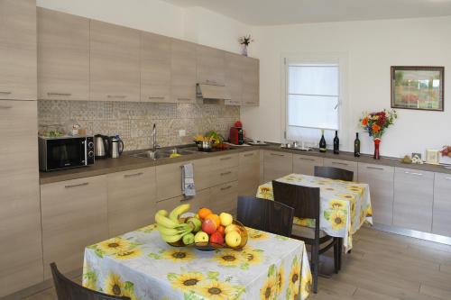 una cocina con una mesa con fruta. en B&B Bianchin via Trieste 67 Fiumicello-Villa Vicentina, en San António