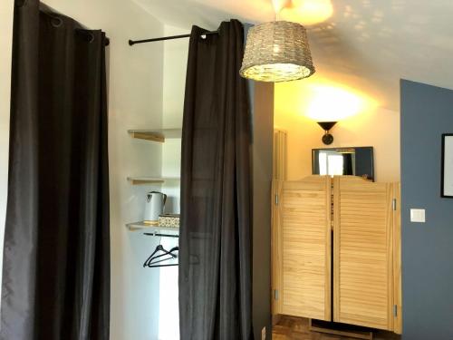 Pokój z zasłoną, szafką i lampką w obiekcie Logement indépendant Bassin d'Arcachon w mieście Le Teich
