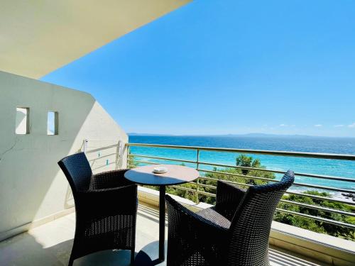 balcón con mesa, sillas y vistas al océano en Studios Afitos, en Afitos