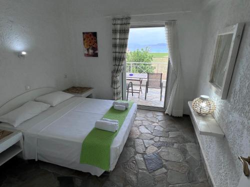 a bedroom with a bed and a balcony with a table at Phoenix Beachside Condos in Kokóni
