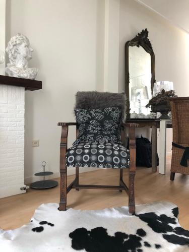 a chair in a room with a mirror at B&B de Tol in Hulst