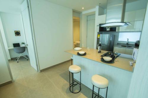a kitchen with a counter and some stools in it at Suite de lujo Distrito 90 in Barranquilla