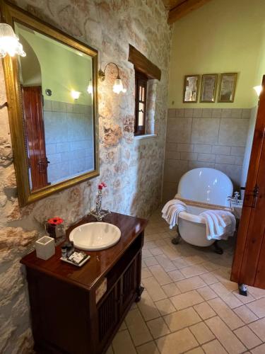 a bathroom with a tub and a sink and a bath tub at Boutique apart-hotel Galini, member of the best small hotels in Greece, Adults only in Volímai