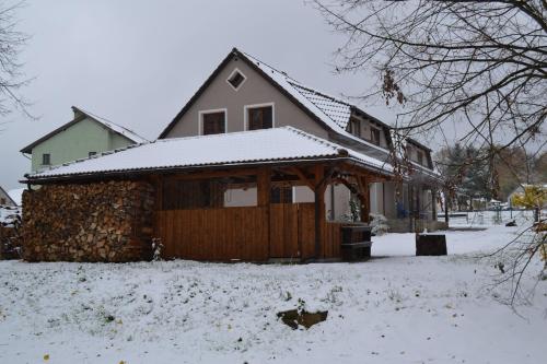a house with a snow covered roof in a yard at Mamut in Rozvadov