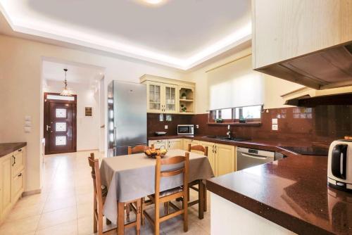 a kitchen with a table and chairs in a kitchen at Villa Maribia with Private pool in Gennadi