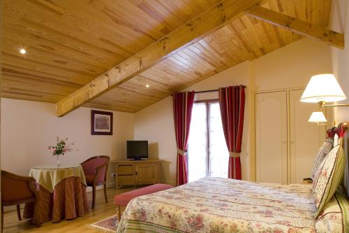 a bedroom with a bed and a table and a television at Hotel Argi Eder in Ainhoa