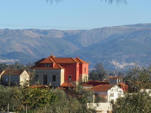 um grupo de casas com montanhas ao fundo em Solar dos Alperces - Serra da Estrela - Turismo de Aldeia em Travancinha