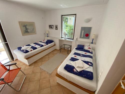 a bedroom with two beds and a desk in it at Blumenhaus (Spiti Louloudia) in Paralía Sergoúlas