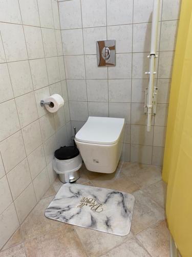 a bathroom with a toilet and a towel on the floor at Blumenhaus (Spiti Louloudia) in Paralía Sergoúlas