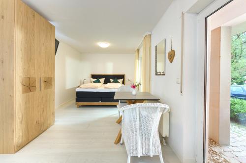 a bedroom with a bed and a table and chairs at Thermen Appartements Gabriela, Appartement 24 qm in Bad Krozingen
