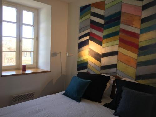 1 dormitorio con 1 cama y una pared colorida en Maison agréable avec vue splendide, en Monze