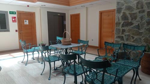 a table and chairs in a room with a stone wall at Hotel Molino in Ronda