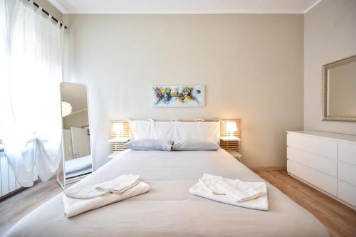 un grande letto bianco in una stanza con specchio di Top Living Apartments - Appartamenti Saluzzo a Torino