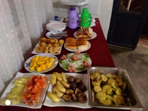 una mesa cubierta con platos de diferentes tipos de alimentos en La paillotte gorilla place kinigi, en Kinigi