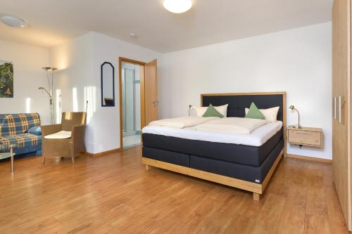 a bedroom with a bed and a chair and a couch at Thermen Appartements Gabriela, Appartemen 53 qm in Bad Krozingen