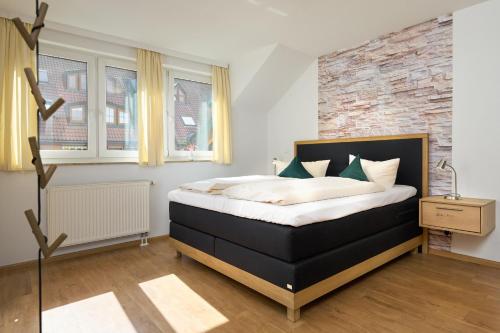a bedroom with a bed and a brick wall at Thermen Appartements Gabriela, 38 qm in Bad Krozingen