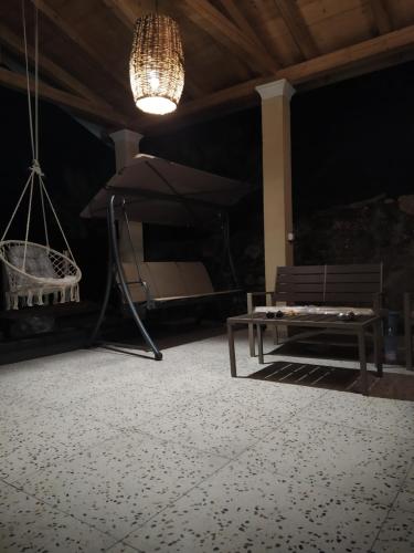 a room with a bench and an umbrella and a lamp at Nikos' Home in Gastourion