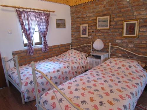 a bedroom with two beds and a brick wall at Studio Apartment Romeo in Velika Gorica