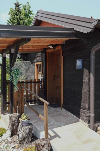 a black house with a wooden door and a porch at Studio Apartment Romeo in Velika Gorica