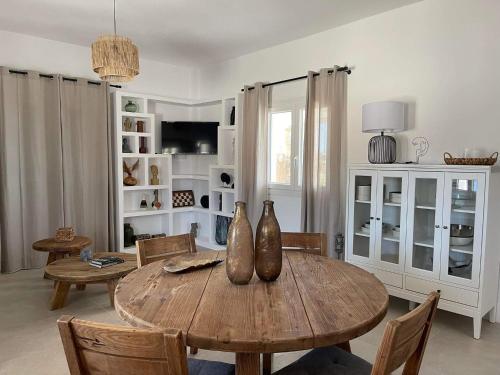 a living room with a wooden table with vases on it at Sorokos Villa Panagia beach in Andiparos