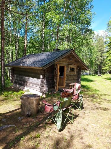 a small log cabin with chairs in front of it at The Old Logging Camp in Yttermalung
