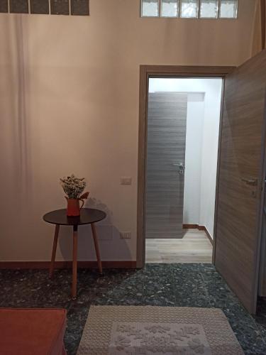 a hallway with a door and a table with a plant on it at Piazza San Giorgio in Dolianova