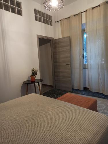 a bedroom with a bed and a door and a table at Piazza San Giorgio in Dolianova