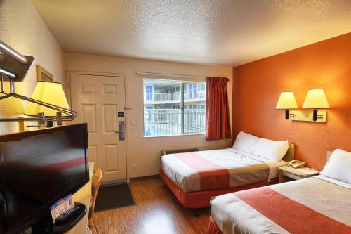 a hotel room with two beds and a flat screen tv at Motel 6-Coeur D'Alene, ID in Coeur d'Alene