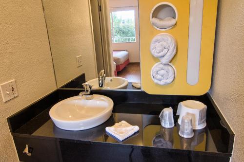 a bathroom with a sink and a mirror and towels at Motel 6-Coeur D'Alene, ID in Coeur d'Alene