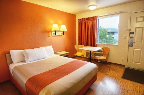 a hotel room with a bed and a table and a window at Motel 6-Coeur D'Alene, ID in Coeur d'Alene