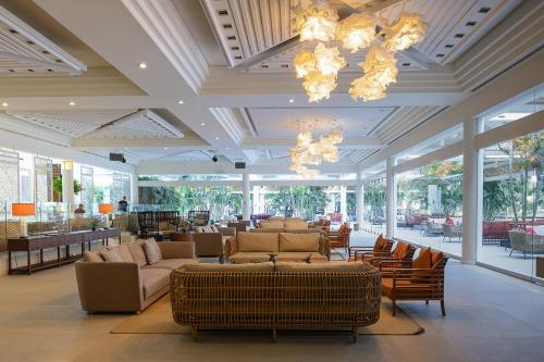 a lobby with couches and chairs and a restaurant at Yam Suf by Isrotel Collection in Eilat