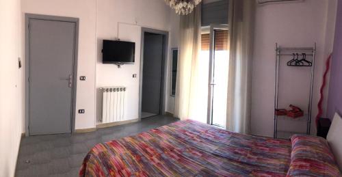 a bedroom with a bed and a flat screen tv at Domus Narciso Gallery in Pompei