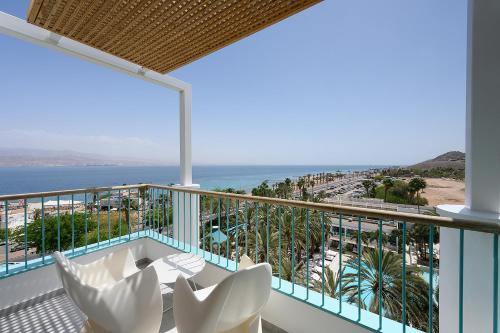a balcony with white chairs and a view of the ocean at Yam Suf by Isrotel Collection in Eilat